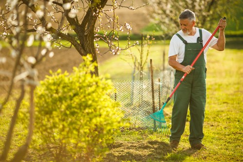 Protected gardener in high-visibility clothing using a trimmer